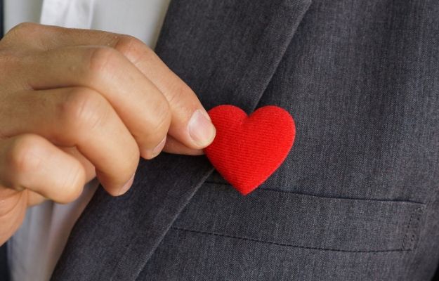 Businessman pulling out a red heart from the pocket of his suit | Take responsibility